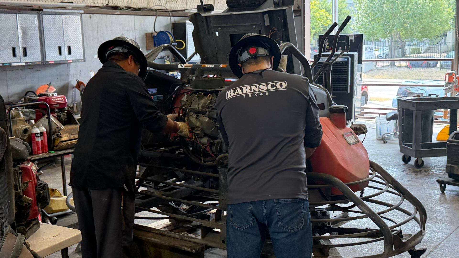 barnsco mechanics working on a ride-on trowel